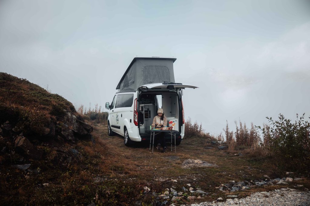 van ouvert tente toit montagne hiver femme assise
