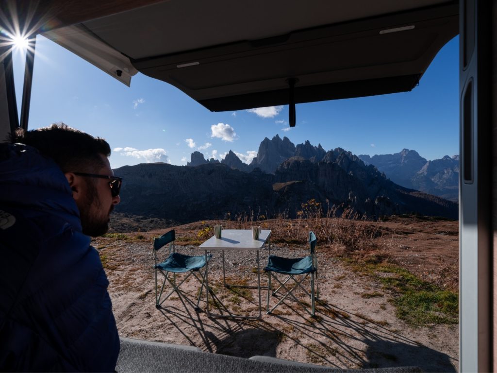 homme table exterieur montagne soleil van